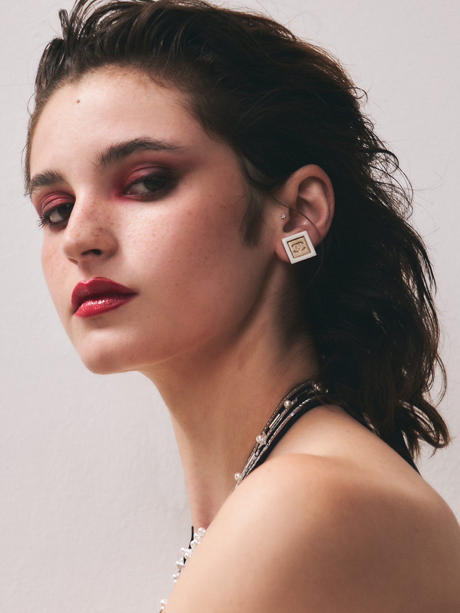 Headshot of a model with bold red eye and lip looking at the camera with a serious expression